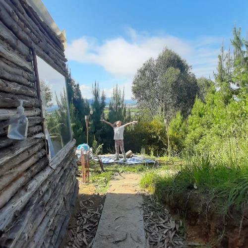 a man standing in front of a house with his arms out at Glamping El Mirador de las estrellas in Bojacá