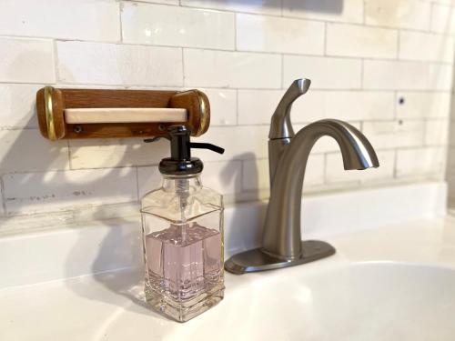 a glass bottle sitting on a sink next to a faucet at Alina & Fanny - Philadelphia S Broad St in Philadelphia