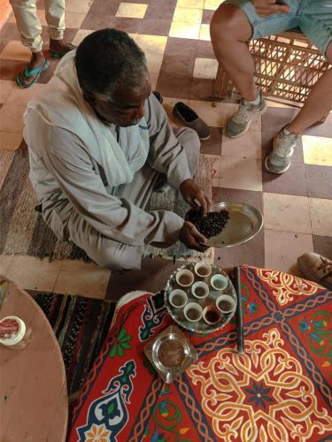 a man sitting on the floor next to a table at Go Inn Backpackers in Aswan