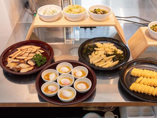 a group of plates of food on a shelf with food at Ariston Hotel Kyoto Jujo in Kyoto