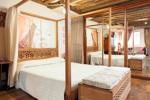 une chambre avec deux lits dans une pièce dans l'établissement Camallo Paris, à Paris