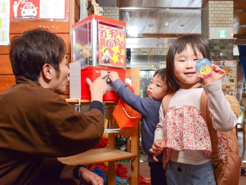 a man taking a picture of a little girl at Kameyama Onsen Hotel in Kimitsu