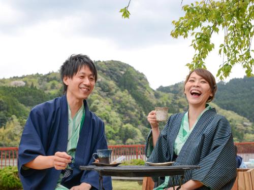 a man and a woman sitting at a table with drinks at Kameyama Onsen Hotel in Kimitsu