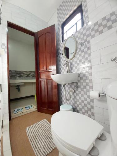 a bathroom with a toilet and a sink and a mirror at Golden Pension House,Palawan in Puerto Princesa City