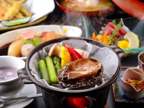 a bowl of food with vegetables and a sandwich at Kameyama Onsen Hotel in Kimitsu