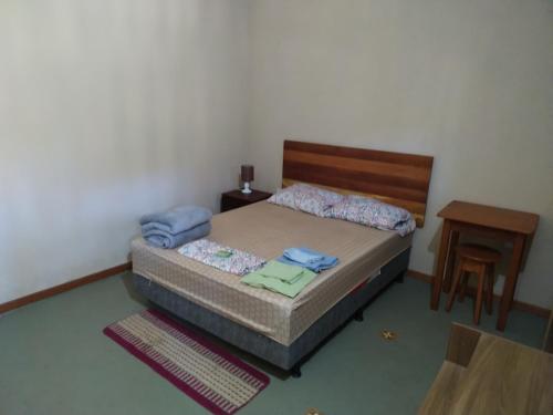 a small bedroom with a bed and a table at Pousada do guariba in Santa Teresa