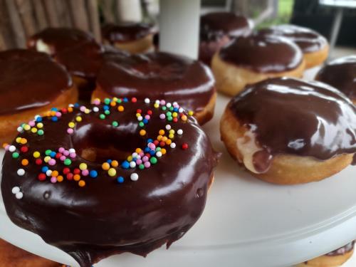 a group of chocolate donuts with sprinkles on a plate at Glamping El Mirador de las estrellas in Bojacá