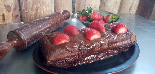 a chocolate cake with strawberries on a plate on a table at Glamping El Mirador de las estrellas in Bojacá
