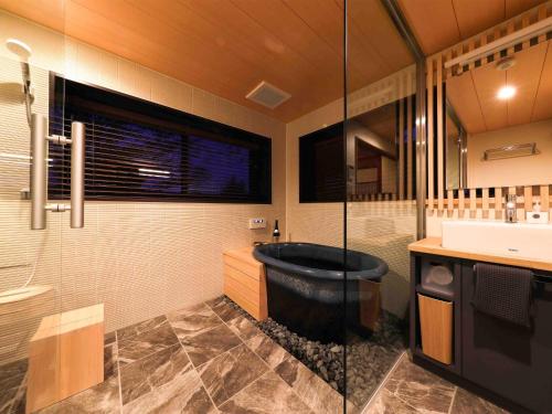 a bathroom with a bath tub and a sink at WABISABI ISURUGI KASHIWAYA - Vacation STAY 34839v in Oyabe