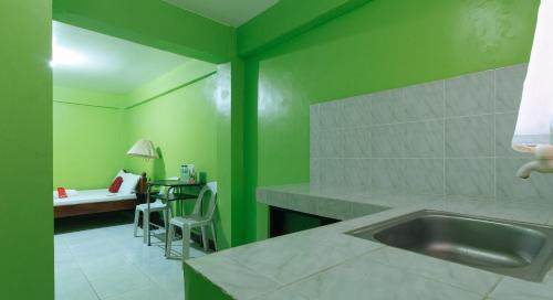 cocina con fregadero y pared verde en RedDoorz Plus near Municipality of Luisiana Laguna en Laguna