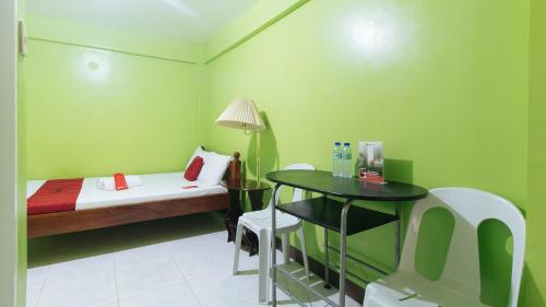 a small room with a bed and a table at RedDoorz Plus near Municipality of Luisiana Laguna in Laguna