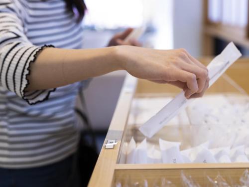 a woman holding a piece of paper on a table at Ariston Hotel Kyoto Jujo in Kyoto