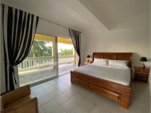 a bedroom with a bed and a view of a balcony at Spring Garden by Mel in Montego Bay