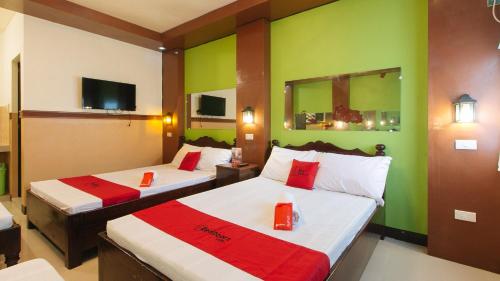 a hotel room with two beds with green walls at RedDoorz Plus near Municipality of Luisiana Laguna in Laguna