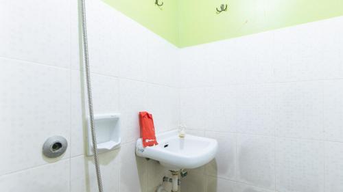 a bathroom with a sink and a red phone at RedDoorz Plus near Municipality of Luisiana Laguna in Laguna