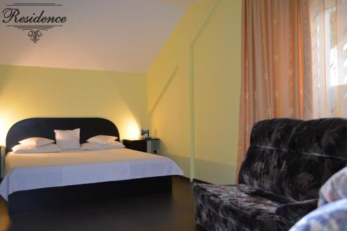 a hotel room with a bed and a couch at Pensiunea Residence in Râmnicu Vâlcea