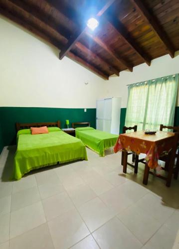 a bedroom with two green beds and a table at MI RIO in Colón