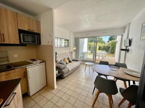 une cuisine et un salon avec un canapé et une table dans l'établissement Quiberon - T2 Rénové avec Jardin, Piscine & Tennis, à 500m des Plages, WIFI Inclus - FR-1-478-225, à Quiberon