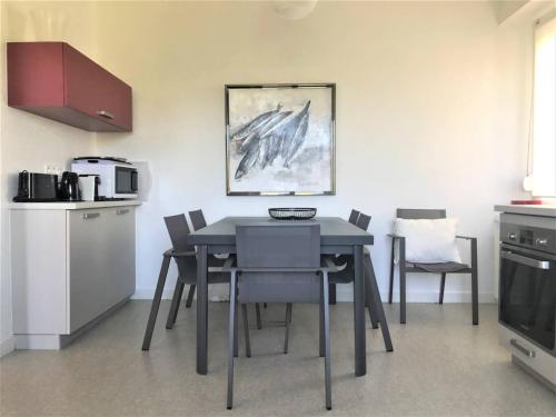 - une table à manger et des chaises dans la cuisine dans l'établissement Maison de charme à 50m du port de Ploumanac'h - FR-1-368-357, à Perros-Guirec