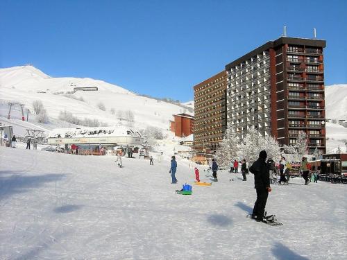 Un groupe de personnes dans la neige devant un bâtiment dans l'établissement Studio lumineux avec balcon - Pied des pistes, piscine, parking et commerces à proximité - FR-1-267-218, au Corbier