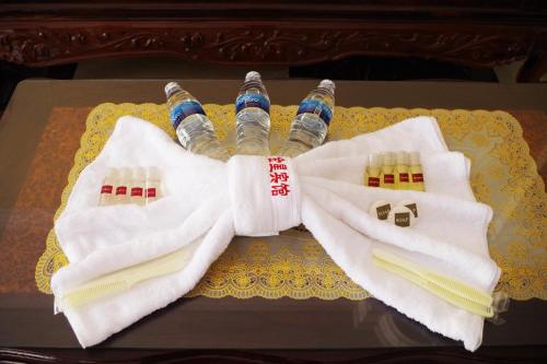 einen Tisch mit 2 Handtüchern, Wasserflaschen und Essstäbchen in der Unterkunft Golden Star Inn in Sihanoukville
