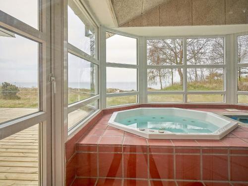 a jacuzzi tub in a room with windows at Luxury Retreat by the Sea - By Traum Ferienwohnungen in Vester Sømarken