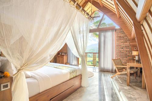 a bedroom with a bed with a mosquito net at Romantic Barn with Mt. Agung Views in Sidemen