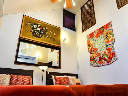 a living room with a couch and a mirror at Maguro House in Osaka