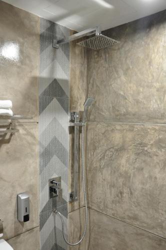 a shower with a glass door in a bathroom at Valya Hotel, Kuala Terengganu in Kuala Terengganu