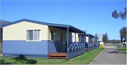 a blue and white house with a porch at BIG4 Waters Edge Holiday Park in Lakes Entrance