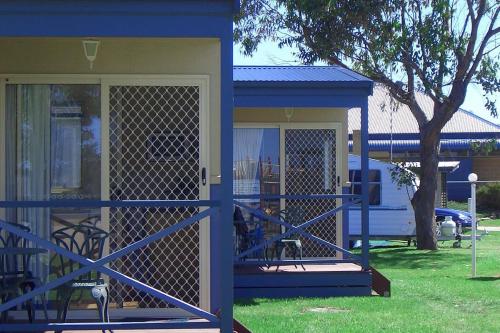 a house with a blue fence and a porch at BIG4 Waters Edge Holiday Park in Lakes Entrance