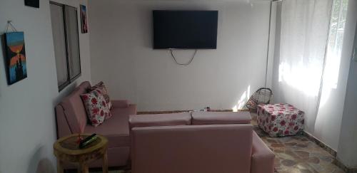 un soggiorno con divano e TV a schermo piatto di Casa campestre Villa Eliana 2 a Calarcá