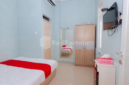 Postel nebo postele na pokoji v ubytování OYO 94494 Krekot Residence Pasar Baru COO Property