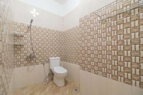 パレンバンにあるUrbanview Hotel Ephe Palembang by RedDoorzのトイレとレンガの壁があるバスルーム