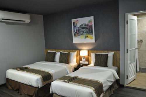 a hotel room with two beds in a room at Valya Hotel, Kuala Terengganu in Kuala Terengganu
