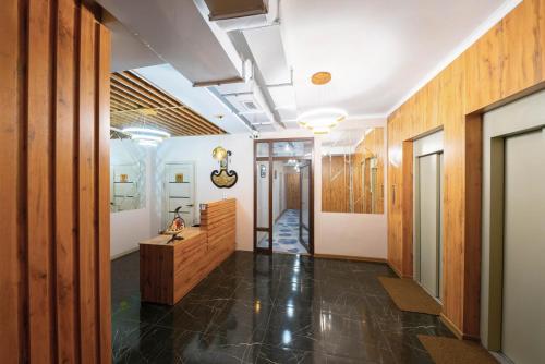 a hallway with wood paneled walls and a hallway with a sink at Kaganat Hostel in Bishkek