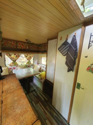 una vista interior de una sala de tren con una mesa en Koppány Pines Rewild Escapes - Vintage Caravan, en Koppányszántó