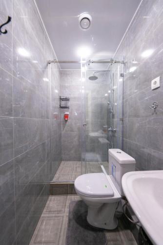 a bathroom with a shower and a toilet and a sink at Kaganat Hostel in Bishkek