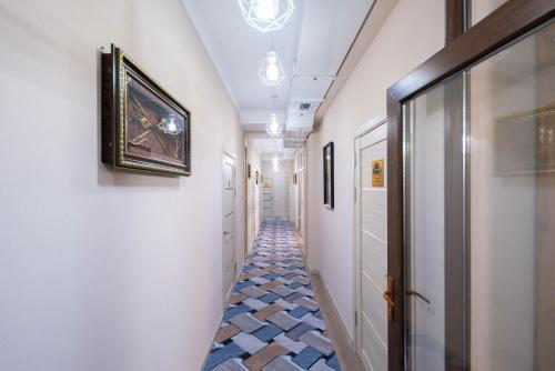 a hallway with a tile floor and white walls at Kaganat Hostel in Bishkek