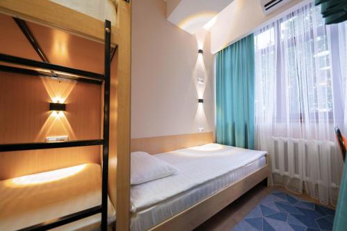 a small bedroom with a bunk bed and a window at Kaganat Hostel in Bishkek