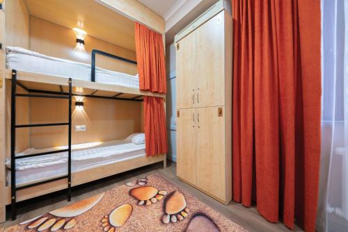 a bunk bed room with two bunk beds and a rug at Kaganat Hostel in Bishkek