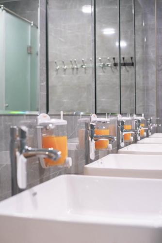 a bathroom with a row of sinks and mirrors at Kaganat Hostel in Bishkek