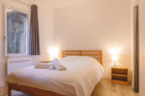 a bedroom with a large white bed with two lamps at Appartement Hypercentre RDC - NEW LOCATION in Bourg-en-Bresse