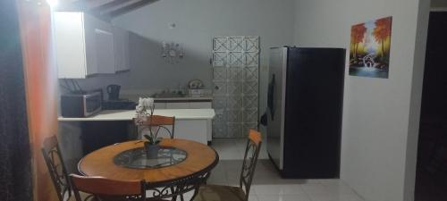 a small kitchen with a table and a refrigerator at Oak Villa Montego Bay 2 in Montego Bay