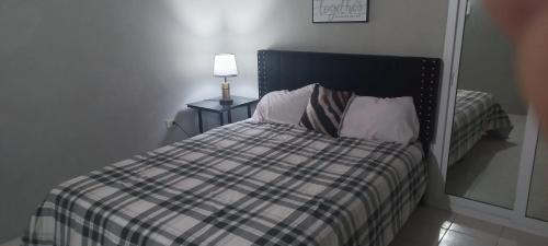 a bedroom with a bed and a lamp on a table at Oak Villa Montego Bay 2 in Montego Bay