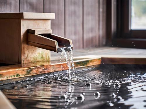 a fountain with water coming out of it at Kameyama Onsen Hotel in Kimitsu