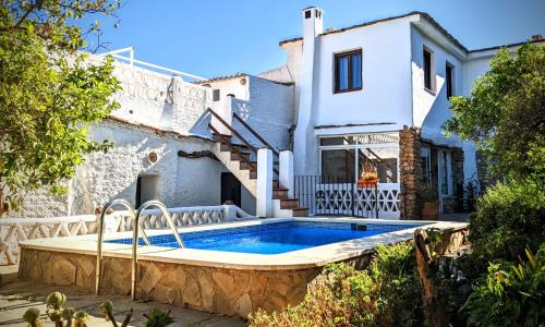 a villa with a swimming pool in front of a house at Casa Jazmin in Órgiva