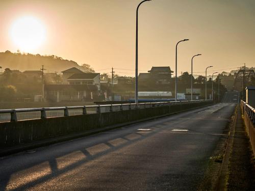 an empty road with street lights on a bridge at Kameyama Onsen Hotel in Kimitsu