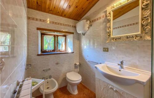 W łazience znajduje się umywalka, toaleta i lustro. w obiekcie Nice Home In Caprese Michelangelo With 1 Bedrooms And Wifi w mieście Caprese Michelangelo