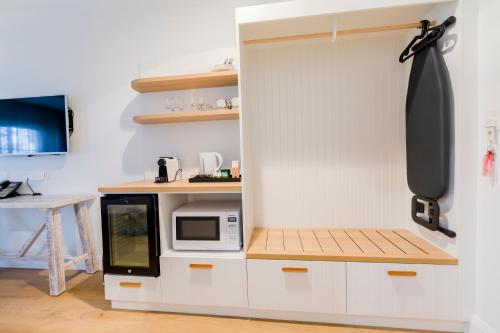 a kitchen with a white cabinet with a microwave at The Quarters, an Ascend Collection Hotel in Wamberal